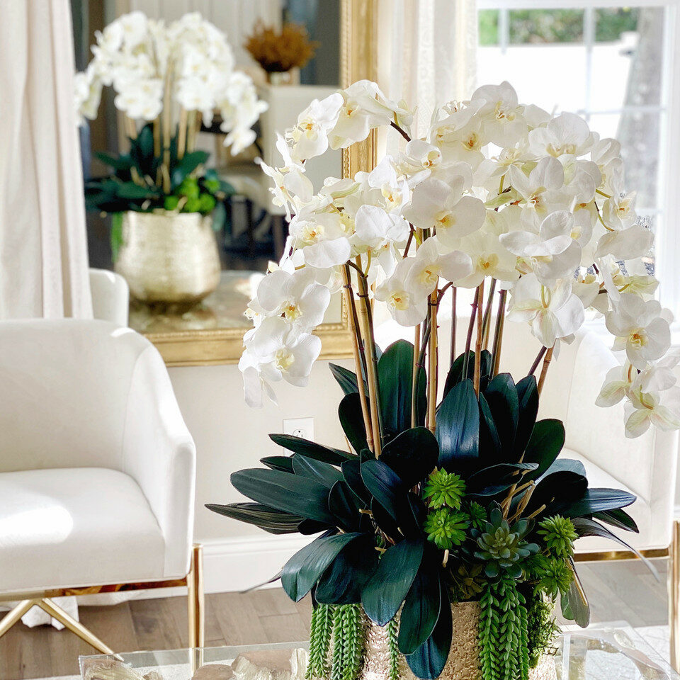 Delaney-Goldvase mit mehreren Stielen von Phalaenopsis-Orchideen und Sukkulenten