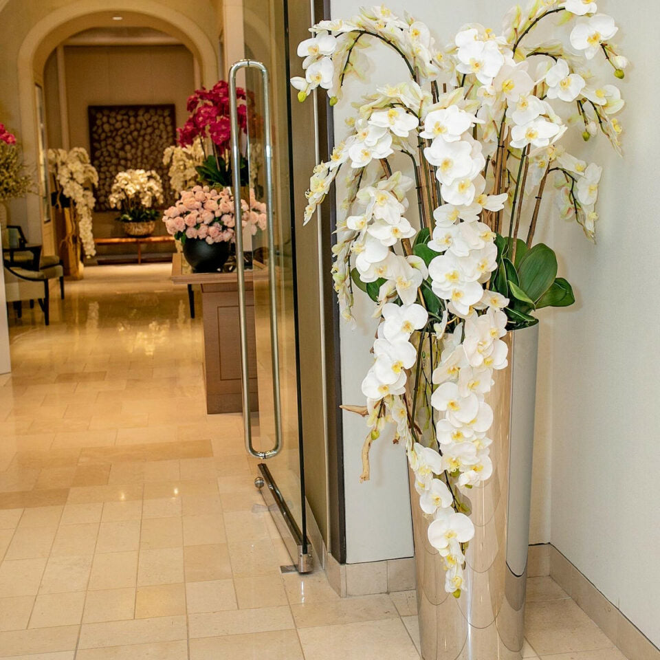 Kaskadierende Phalaenopsis-Orchideen auf einem Kegel aus poliertem Edelstahl
