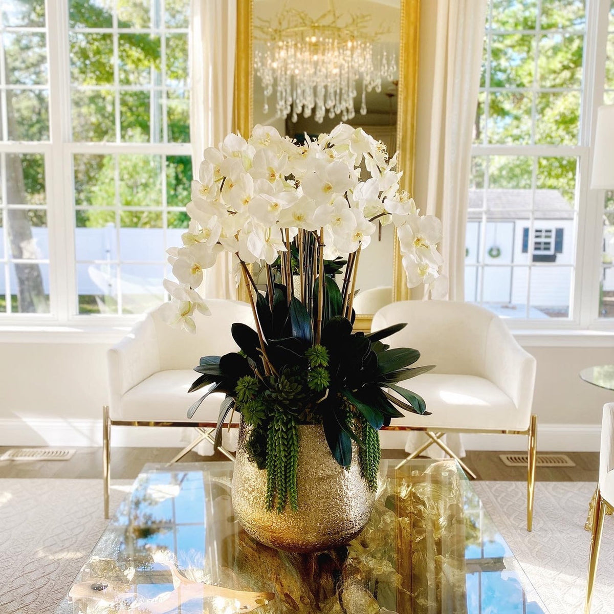 Delaney-Goldvase mit mehreren Stielen von Phalaenopsis-Orchideen und Sukkulenten