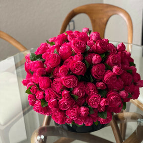 Dunkelrosa englische Rosen in einer schwarzen Glasvase