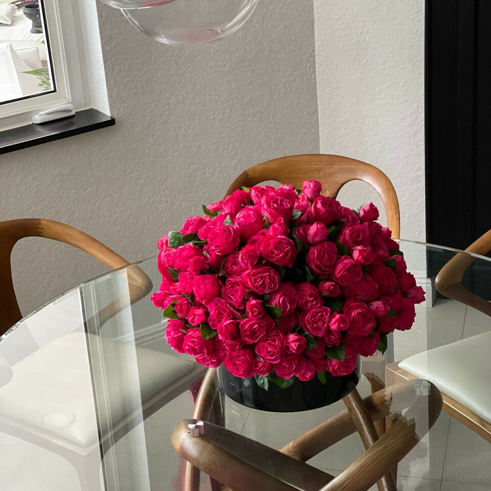 Dunkelrosa englische Rosen in einer schwarzen Glasvase