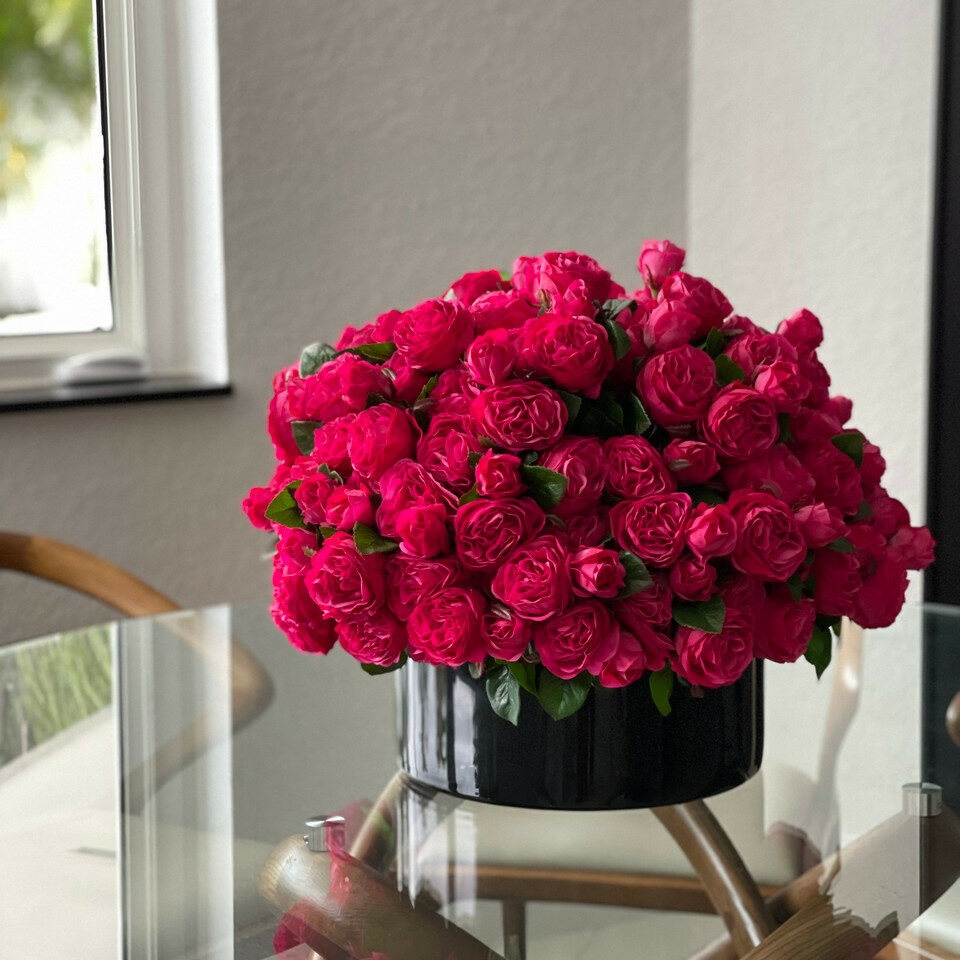 Dunkelrosa englische Rosen in einer schwarzen Glasvase