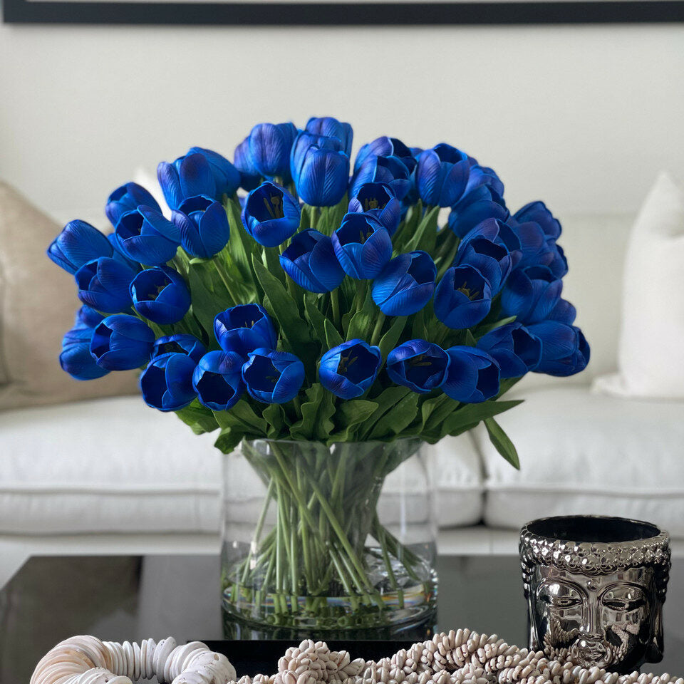 Arrangement aus blauen Tulpen in einer großen zylindrischen Vase