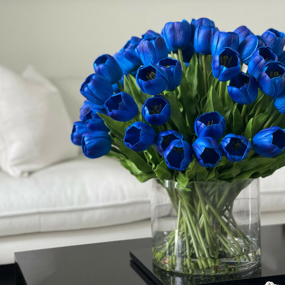 Arrangement aus blauen Tulpen in einer großen zylindrischen Vase
