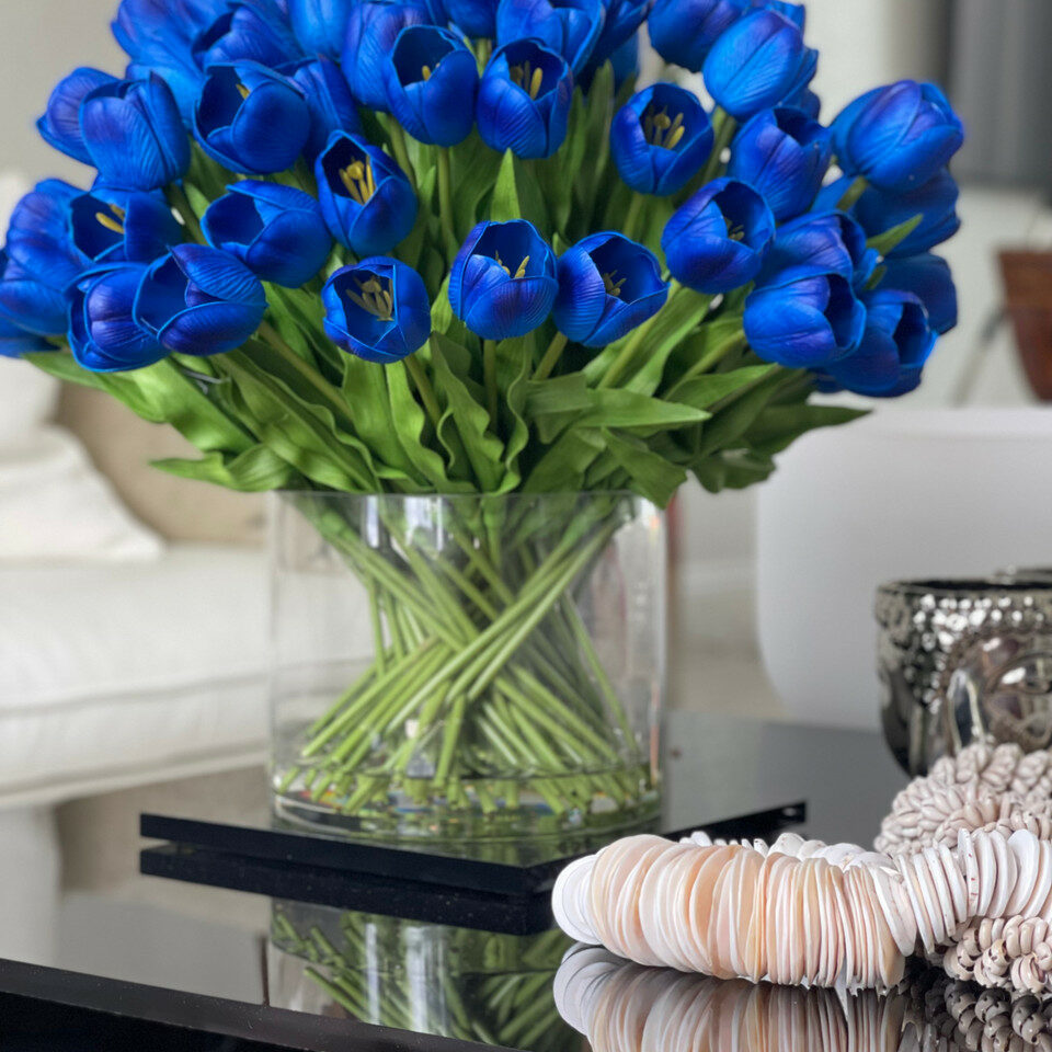 Arrangement aus blauen Tulpen in einer großen zylindrischen Vase