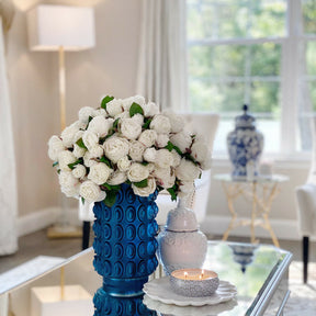 Weiße englische Rosen in einer blauen strukturierten Vase