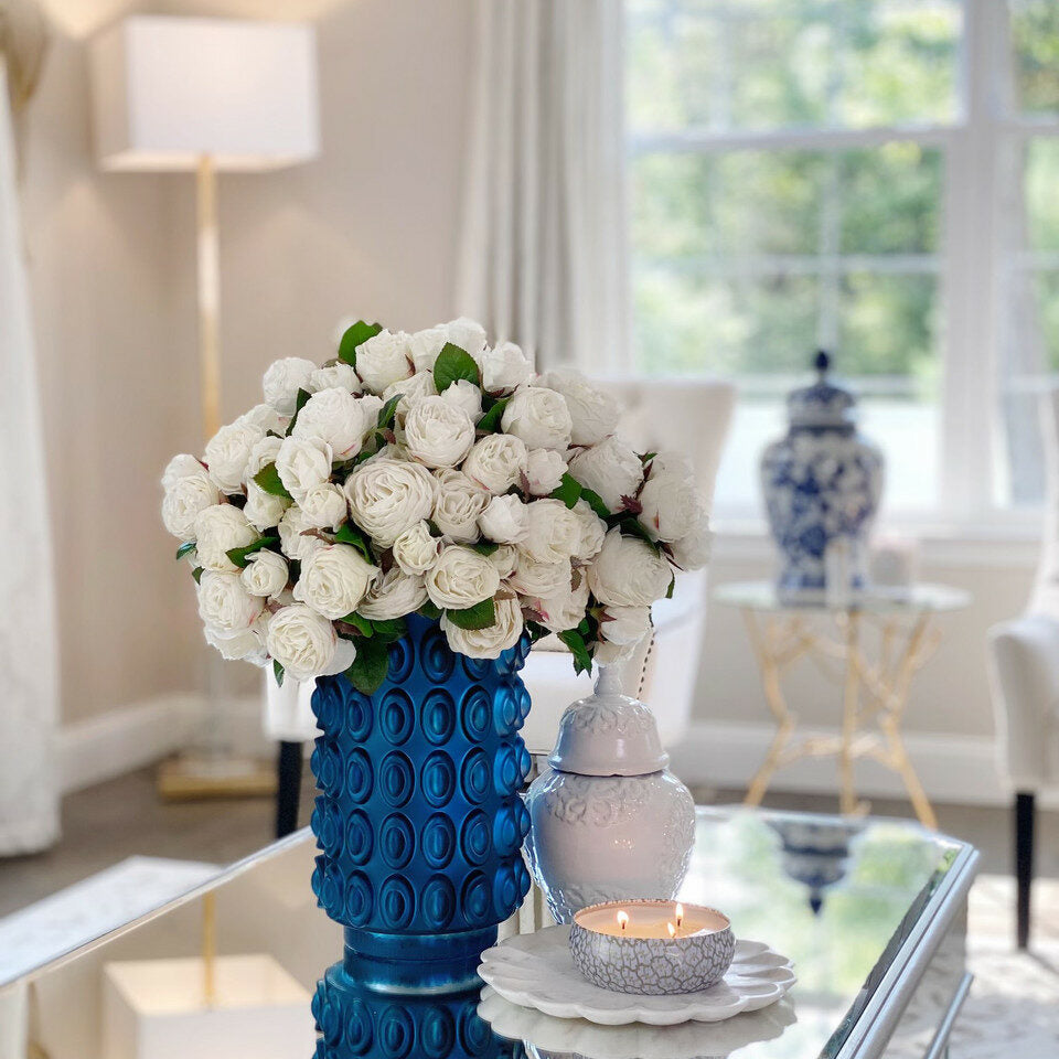 Weiße englische Rosen in einer blauen strukturierten Vase
