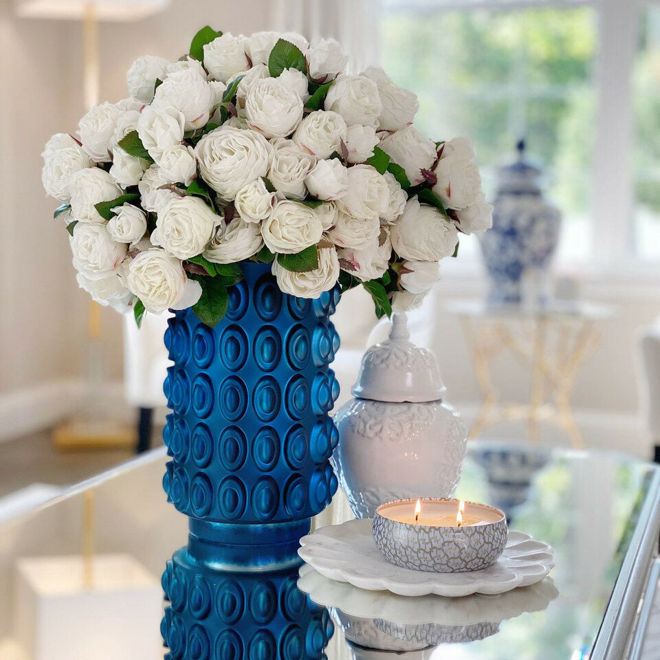 Weiße englische Rosen in einer blauen strukturierten Vase
