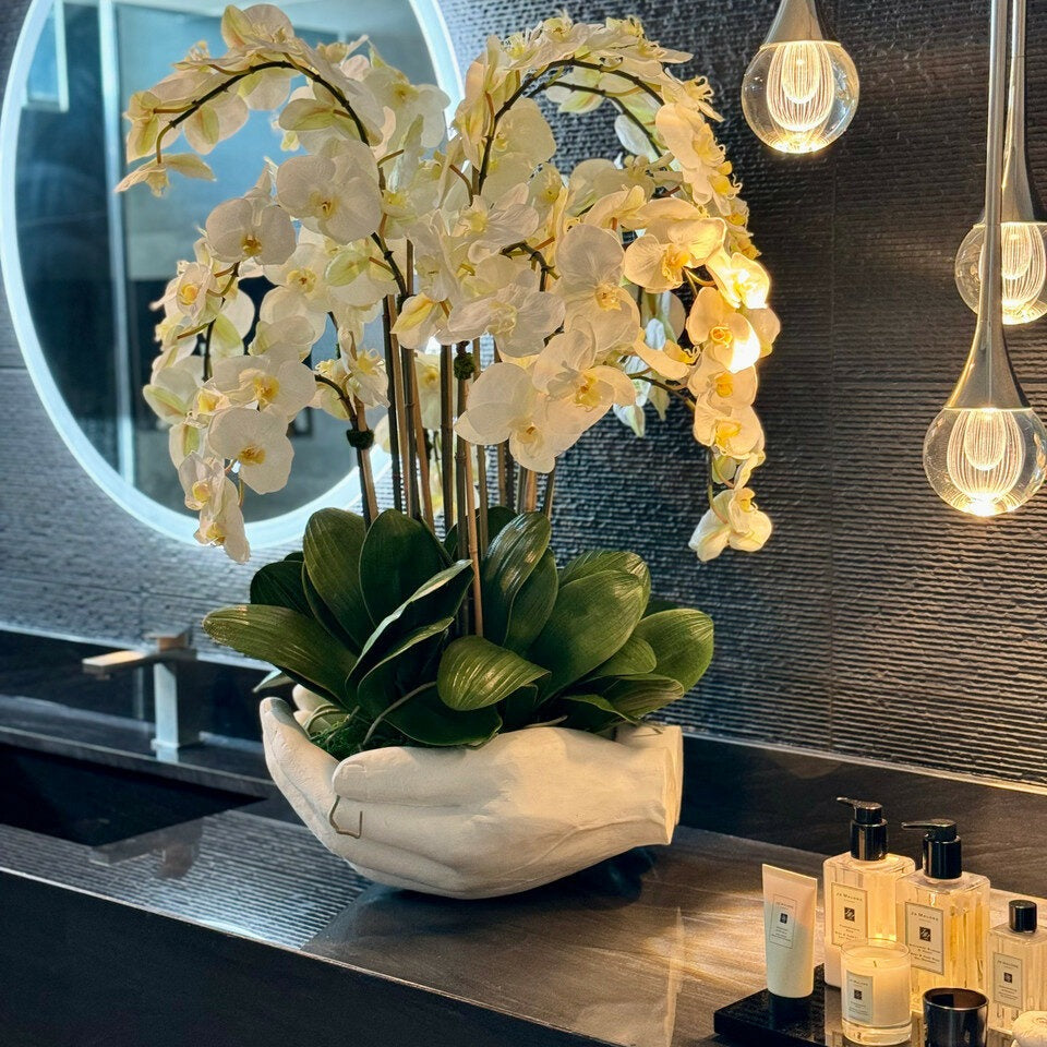 Weiße Phalaenopsis-Orchideen in einer Vase, offene Handskulptur