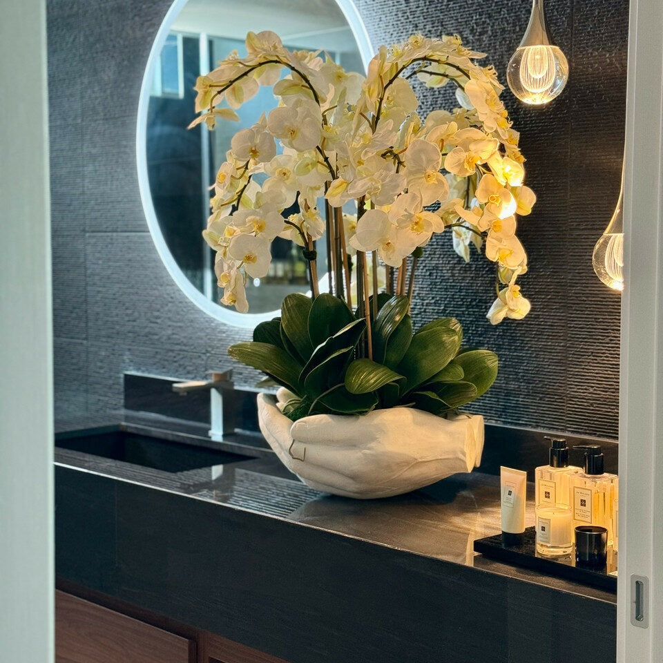Weiße Phalaenopsis-Orchideen in einer Vase, offene Handskulptur